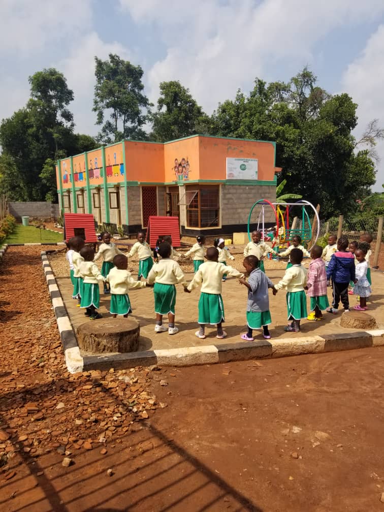 Children holding hands in a circle in the school's playground